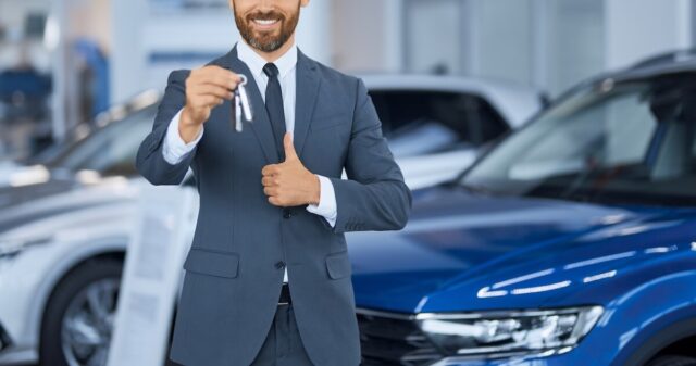 close-up-bearded-man-suit-showing-keys-from-new-car (1)