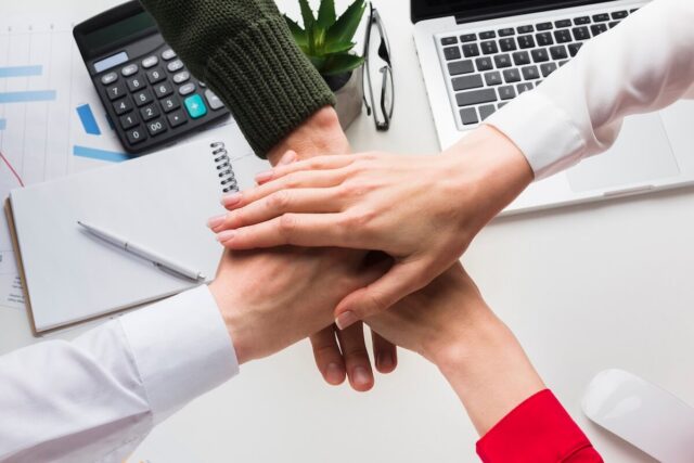 top-view-hands-together-work-desk (1)